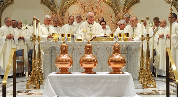 With three vessel of Blessed olive oil at the foot of the altar Bishop Richard Malone begins to bless the gifts at St. Joseph Cathedral during the annual Chrism Mass. (Dan Cappellazzo/Staff Photographer)